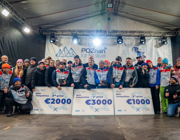 Organizatorzy i rzeźbiarze pozują do wspólnego zdjęcia